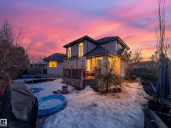Back of property featuring a trampoline, a deck, and stucco siding - 