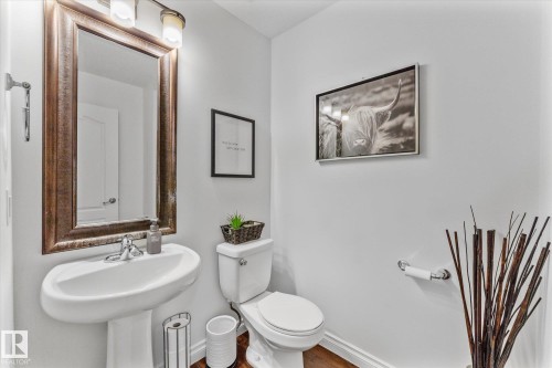 Bathroom featuring toilet and wood finished floors - 13 Heron Link, Spruce Grove, AB - Indoor Photo Showing Bathroom