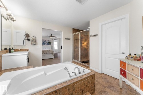 Full bathroom with vanity, a bath, a stall shower, ensuite bathroom, and ceiling fan - 13 Heron Link, Spruce Grove, AB - Indoor Photo Showing Bathroom