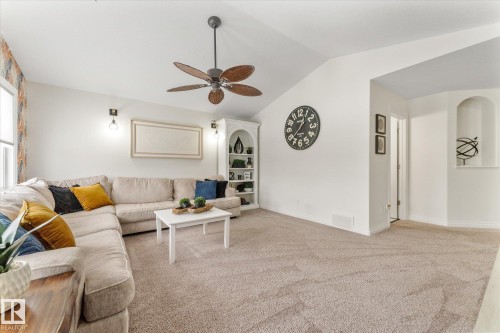 Living room with vaulted ceiling, light colored carpet, and a ceiling fan - 13 Heron Link, Spruce Grove, AB - Indoor Photo Showing Living Room