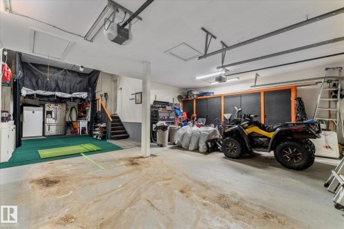 Garage featuring a garage door opener and freestanding refrigerator - 13 Heron Link, Spruce Grove, AB - Indoor Photo Showing Garage