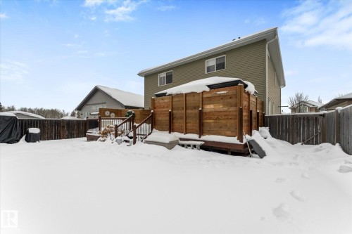 Snow covered house featuring a fenced backyard and a wooden deck - 13 Heron Link, Spruce Grove, AB - Outdoor With Exterior