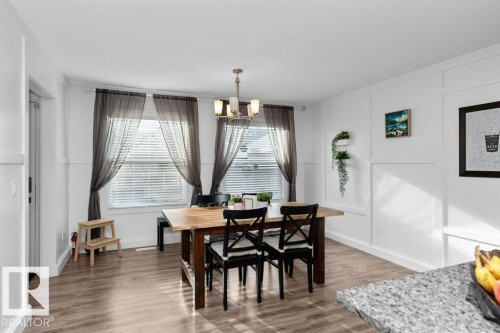 Dining area with a decorative wall, a chandelier, wood finished floors, and plenty of natural light - 2607 20 Avenue, Edmonton, AB - Indoor Photo Showing Other Room