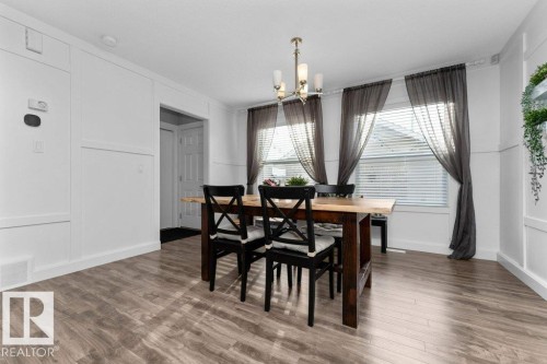 Dining space featuring wood finished floors, hanging lights, and a decorative wall - 2607 20 Avenue, Edmonton, AB - Indoor Photo Showing Dining Room