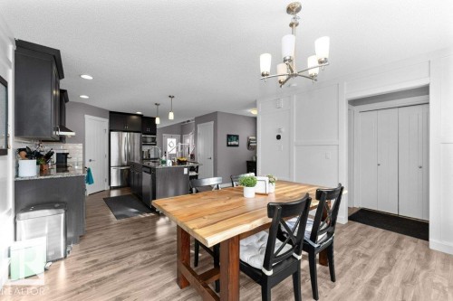 Dining room with light wood-style floors, a textured ceiling, and hanging lights - 2607 20 Avenue, Edmonton, AB - Indoor Photo Showing Dining Room