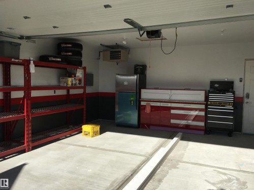 Garage featuring a heating unit, freestanding refrigerator, and a garage door opener - 2607 20 Avenue, Edmonton, AB - Indoor Photo Showing Garage