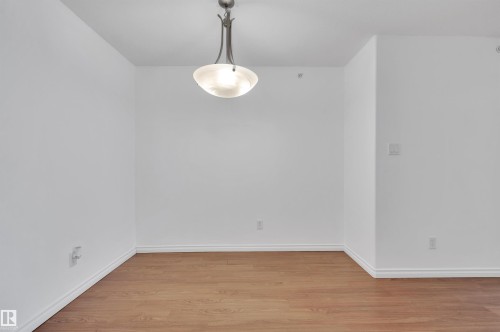 Unfurnished dining area featuring light wood-style flooring and baseboards - 422 7909 71 Street, Edmonton, AB - Indoor Photo Showing Other Room