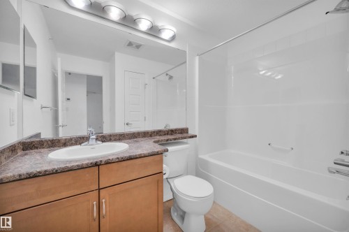 Bathroom featuring vanity, shower / tub combination, and light tile patterned floors - 422 7909 71 Street, Edmonton, AB - Indoor Photo Showing Bathroom