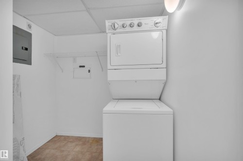 Laundry room with electric panel, stacked washer / drying machine, and a drop ceiling - 422 7909 71 Street, Edmonton, AB - Indoor Photo Showing Laundry Room