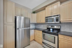 Kitchen with stainless steel appliances, decorative backsplash, and light wood finish cabinetry - 