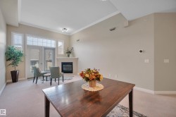 Dining space with light carpet, crown molding, and a glass covered fireplace - 