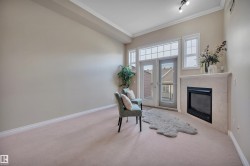 Sitting room with crown molding, carpet, and a fireplace - 