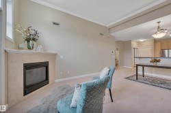 Living area with light colored carpet, a fireplace, and crown molding - 