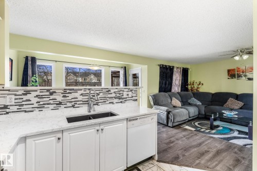 Living room featuring a textured ceiling, light wood-style floors, and ceiling fan - 13148 151 Avenue, Edmonton, AB - Indoor