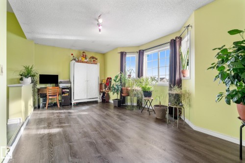 Living area featuring an office area, dark wood-type flooring, and a textured ceiling - 13148 151 Avenue, Edmonton, AB - Indoor