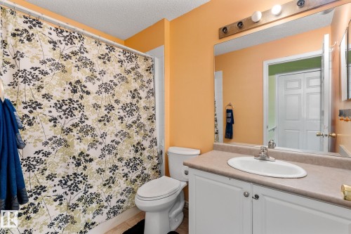 Full bath with vanity, curtained shower, a textured ceiling, and tile patterned floors - 13148 151 Avenue, Edmonton, AB - Indoor Photo Showing Bathroom
