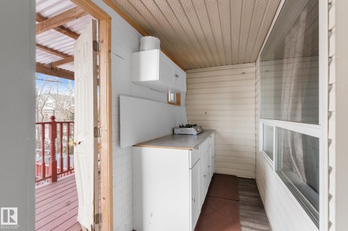 Kitchen featuring white cabinetry, light countertops, and wood finished floors - 13148 151 Avenue, Edmonton, AB -  With Exterior