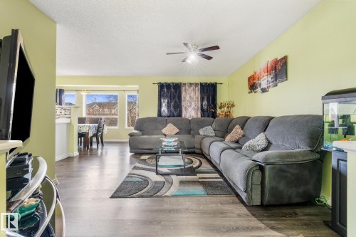 Living room with wood finished floors, a textured ceiling, and ceiling fan - 13148 151 Avenue, Edmonton, AB - Indoor Photo Showing Living Room