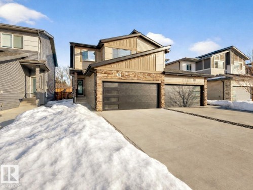 View of front of house with stone siding, concrete driveway, and an attached garage - 74 Royal Street, St. Albert, AB - Outdoor