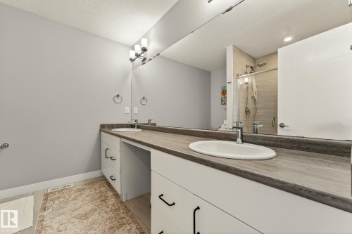 Full bathroom featuring a shower stall, double vanity, and light wood-type flooring - 74 Royal Street, St. Albert, AB - Indoor Photo Showing Bathroom