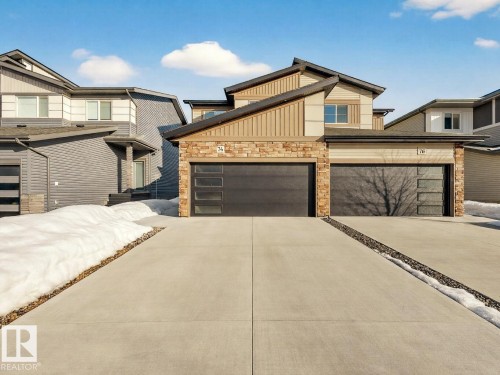 Contemporary home with stone siding, concrete driveway, and an attached garage - 74 Royal Street, St. Albert, AB - Outdoor With Facade