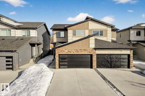Modern home featuring stone siding, concrete driveway, a shingled roof, and a garage - 74 Royal Street, St. Albert, AB - Outdoor