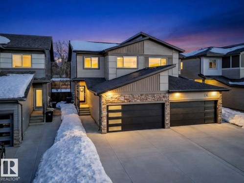 Contemporary home with stone siding, concrete driveway, board and batten siding, entry steps, and an attached garage - 74 Royal Street, St. Albert, AB - Outdoor