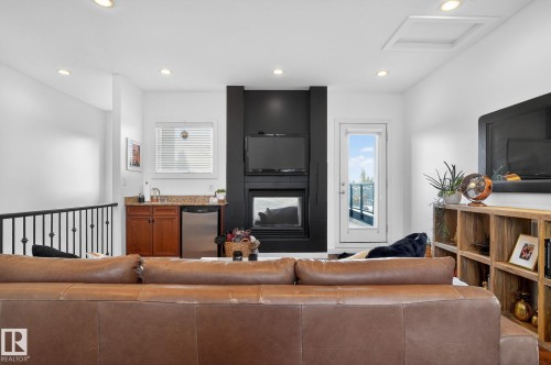 Living area featuring recessed lighting and a multi sided fireplace - 1 9561 143 Street Nw, Edmonton, AB - Indoor Photo Showing Living Room With Fireplace