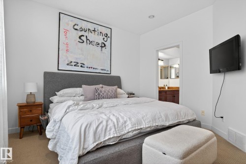 Carpeted bedroom featuring baseboards and ensuite bathroom - 1 9561 143 Street Nw, Edmonton, AB - Indoor Photo Showing Bedroom