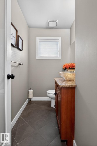 Half bathroom with vanity and dark tile patterned floors - 1 9561 143 Street Nw, Edmonton, AB - Indoor Photo Showing Bathroom