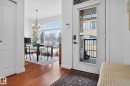Foyer entrance with suspended lighting and dark wood finished floors - 1 9561 143 Street Nw, Edmonton, AB  - Indoor Photo Showing Other Room 