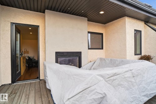 Interior space with recessed lighting, wood-type flooring, an outdoor fireplace, and a textured wall - 1 9561 143 Street Nw, Edmonton, AB - Outdoor With Exterior