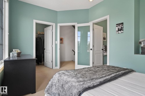 Bedroom with light colored carpet and a walk in closet - 1 9561 143 Street Nw, Edmonton, AB - Indoor Photo Showing Bedroom