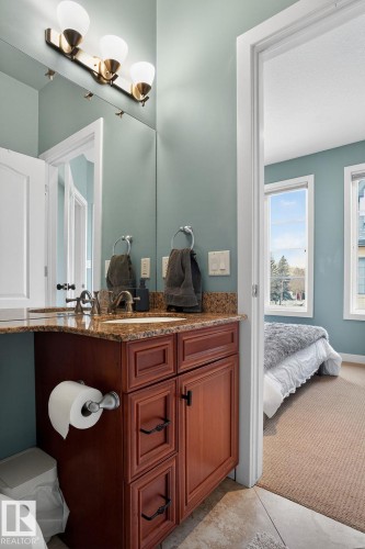 Bathroom with vanity, light colored carpet, and ensuite bath - 1 9561 143 Street Nw, Edmonton, AB - Indoor Photo Showing Other Room