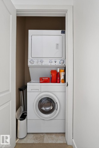 Laundry area with stacked washer and clothes dryer - 1 9561 143 Street Nw, Edmonton, AB - Indoor Photo Showing Laundry Room