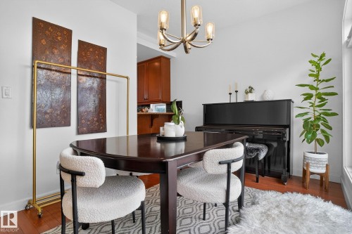 Dining space featuring hardwood / wood-style floors and suspended lighting - 1 9561 143 Street Nw, Edmonton, AB - Indoor Photo Showing Dining Room