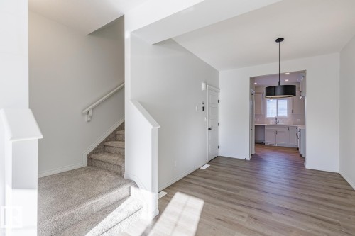 Stairway featuring wood finished floors and baseboards - 90 Dansereau Way N, Beaumont, AB - Indoor Photo Showing Other Room