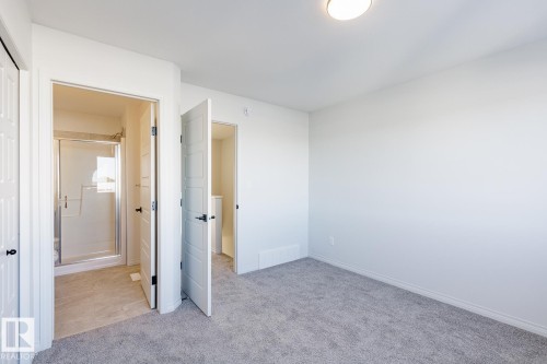 Unfurnished bedroom featuring light colored carpet and ensuite bath - 90 Dansereau Way N, Beaumont, AB - Indoor Photo Showing Other Room