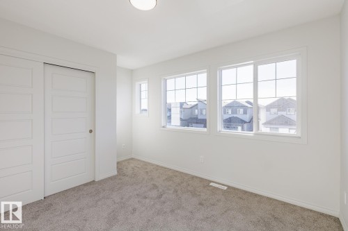 Unfurnished bedroom featuring a closet and light carpet - 90 Dansereau Way N, Beaumont, AB - Indoor Photo Showing Other Room
