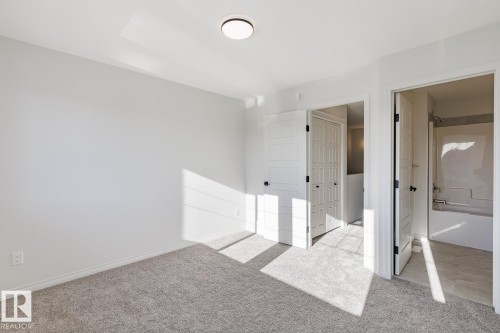 Unfurnished bedroom featuring carpet floors and ensuite bath - 90 Dansereau Way N, Beaumont, AB - Indoor Photo Showing Other Room