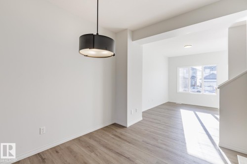 Unfurnished dining area featuring light wood-type flooring - 90 Dansereau Way N, Beaumont, AB - Indoor Photo Showing Other Room