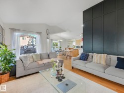 Living area featuring lofted ceiling, light wood-type flooring, and hanging lights - 