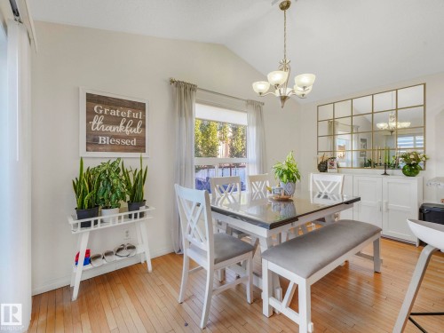 Dining area with light wood-style floors, vaulted ceiling, and a chandelier - 3239 21 Street, Edmonton, AB - Indoor Photo Showing Dining Room