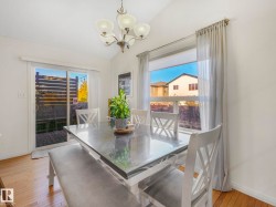 Dining space with light wood finished floors, lofted ceiling, and a chandelier - 