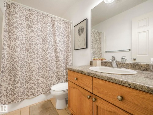 Bathroom with vanity, light tile patterned floors, and shower / bath combo - 3239 21 Street, Edmonton, AB - Indoor Photo Showing Bathroom