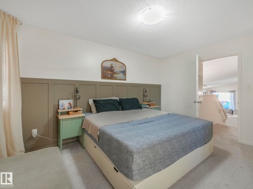 Bedroom featuring a decorative wall, carpet floors, a wainscoted wall, and a textured ceiling - 3239 21 Street, Edmonton, AB - Indoor Photo Showing Bedroom