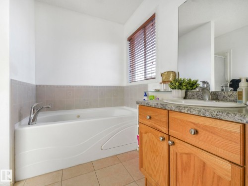 Bathroom with vanity, a bath, and light tile patterned floors - 3239 21 Street, Edmonton, AB - Indoor Photo Showing Bathroom