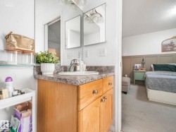 Bathroom with vanity, light carpet, a textured ceiling, wainscoting, and a decorative wall - 