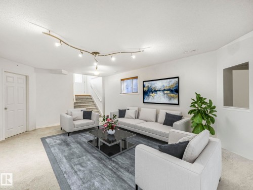 Living room featuring light colored carpet and a textured ceiling - 3239 21 Street, Edmonton, AB - Indoor Photo Showing Living Room