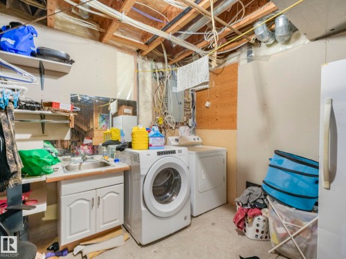 Laundry room with independent washer and dryer, electric panel, and concrete flooring - 3239 21 Street, Edmonton, AB - Indoor Photo Showing Laundry Room